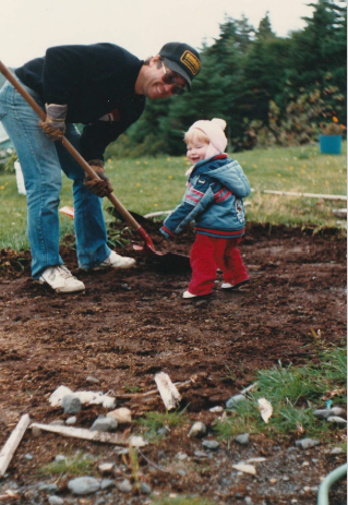 A man and child laying down grounding for a Greenhouse.